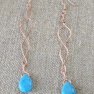 Long twisted copper earrings on copper colored french wire with dyed turquoise teardrops handing from the bottom of each earring