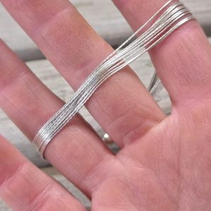 Finely Stranded Sterling Silver Bracelet with Lobster Clasp in model's hand showing the strands flow independently