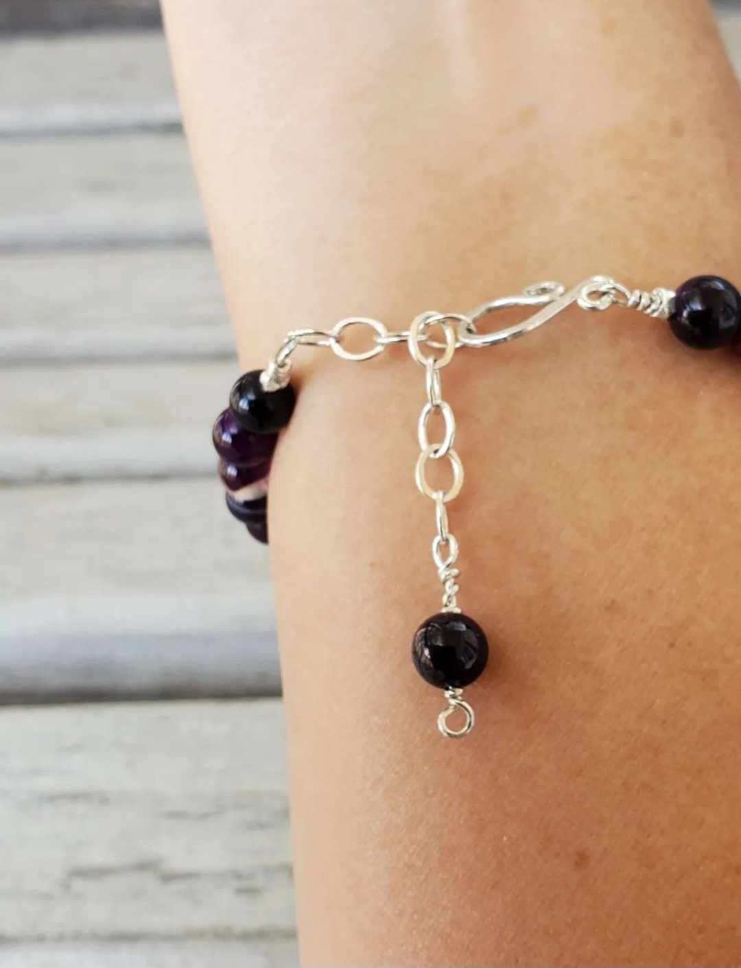 Glass Purple Round Beads with Silver Beaded Accents on sterling silver wire with a sterling handcrafted clasp with a chain extended for sizing shown on model's arm