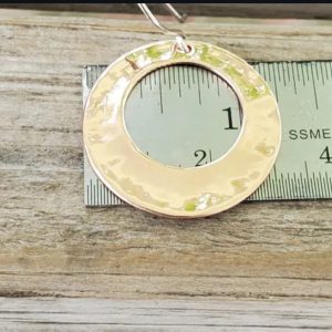 Hammered copper circles with circular center cutout on sterling silver french wire shown on ruler to indicate they are roughly 1 1/4" wide