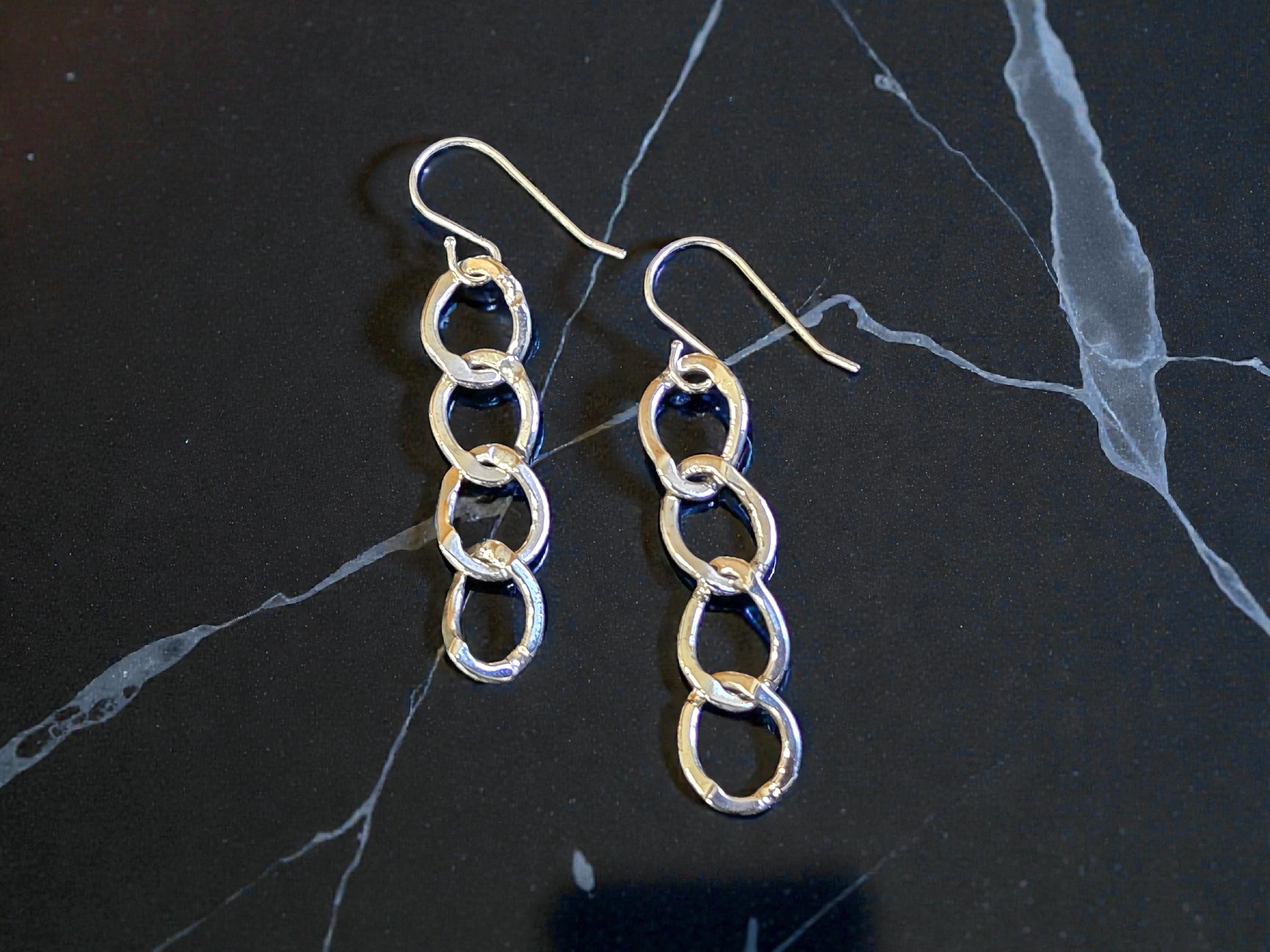 Oval Link Sterling Silver French Wire earrings on a marble surface to enhance the look of the silver links, the french wire, and the polished finish.