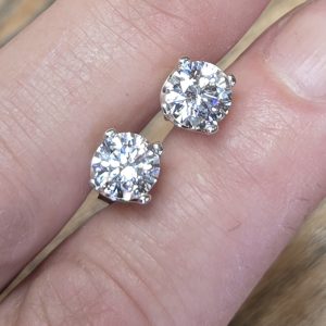 Sterling Silver CZ Post Earrings shown between model's fingers to show colors in the stone.