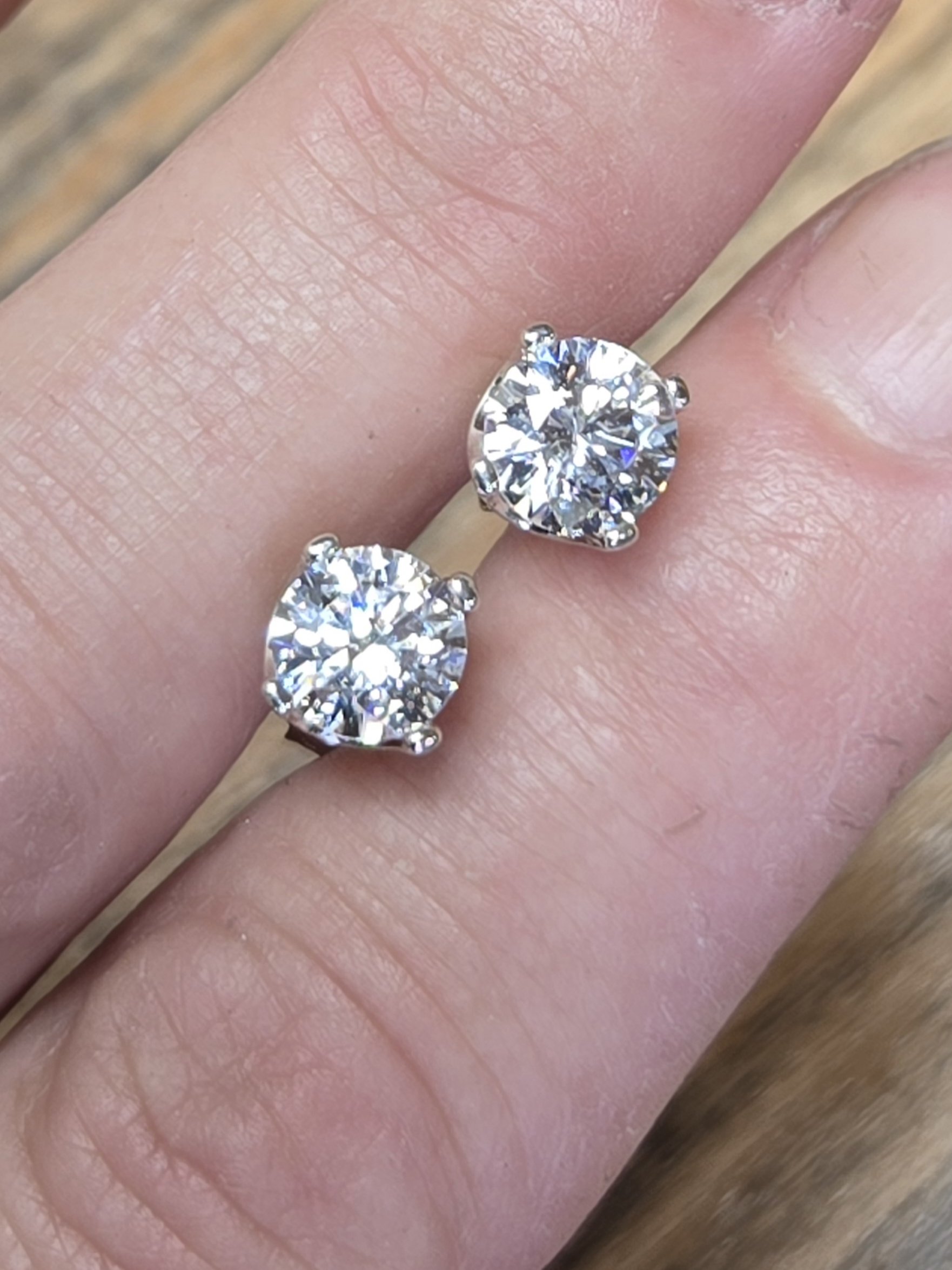 Sterling Silver CZ Post Earrings shown between model's fingers to show colors in the stone.