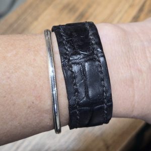 Black Alligator Leather Wrap Bracelet shown on a model's wrist with a sterling silver bangle.